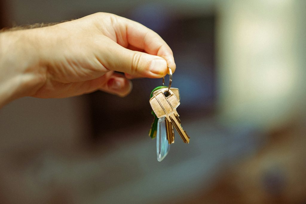 Une main tenant les clés d'un logement, évoquant la transmission du patrimoine familial
